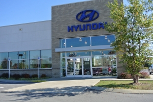 A close-up view of a local Hyundai dealership. Interior lights are visible through their transparent facade. 